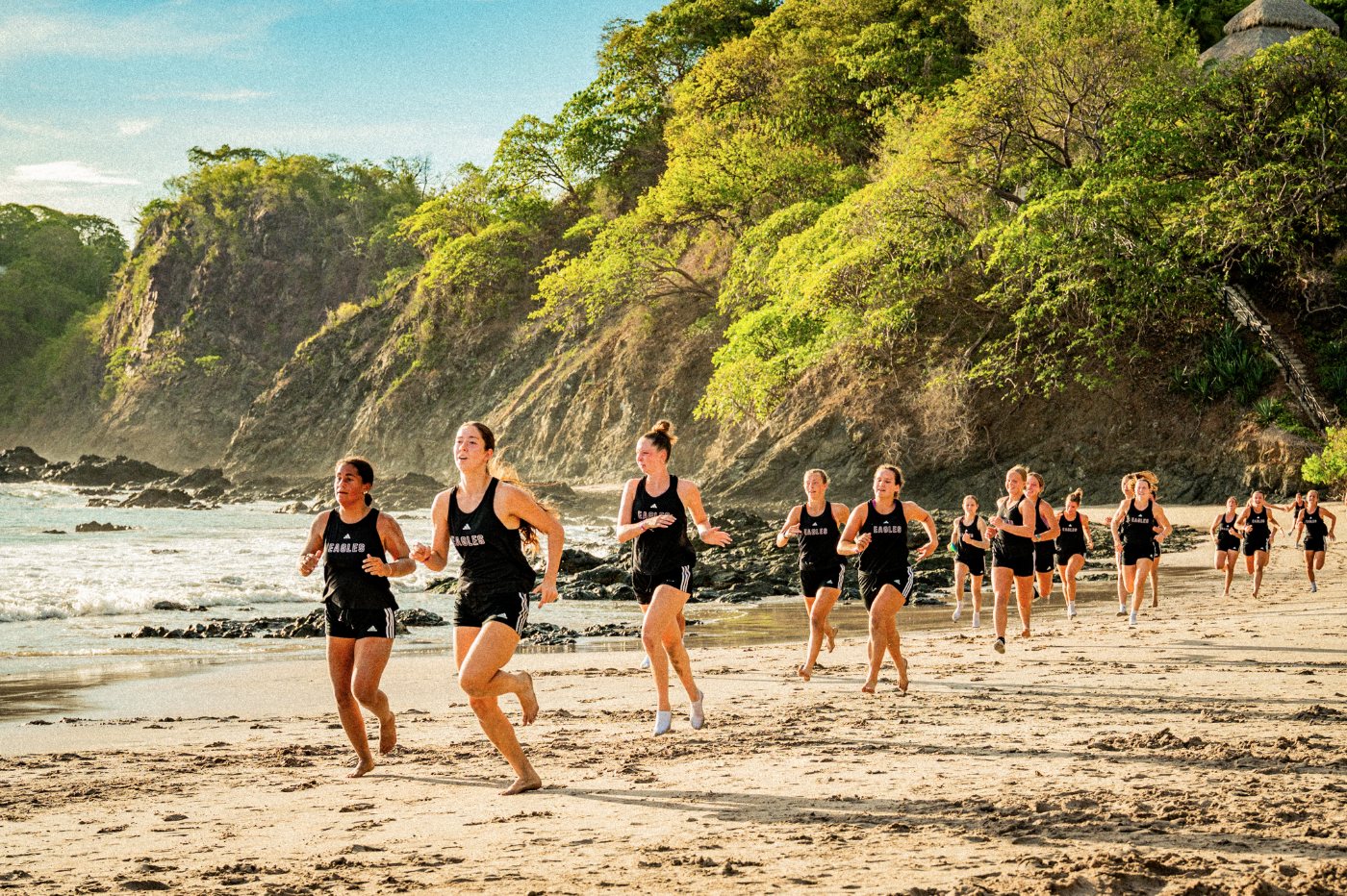 Visiting women's squad running together on the beach in Costa Rica