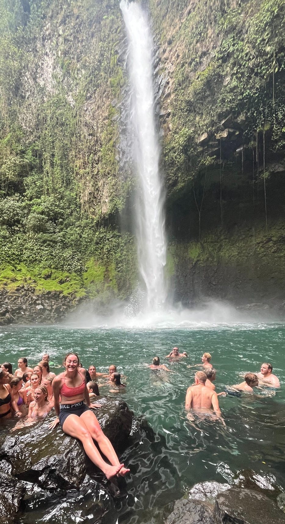 Team swimming at the base of a Costa Rican waterfall